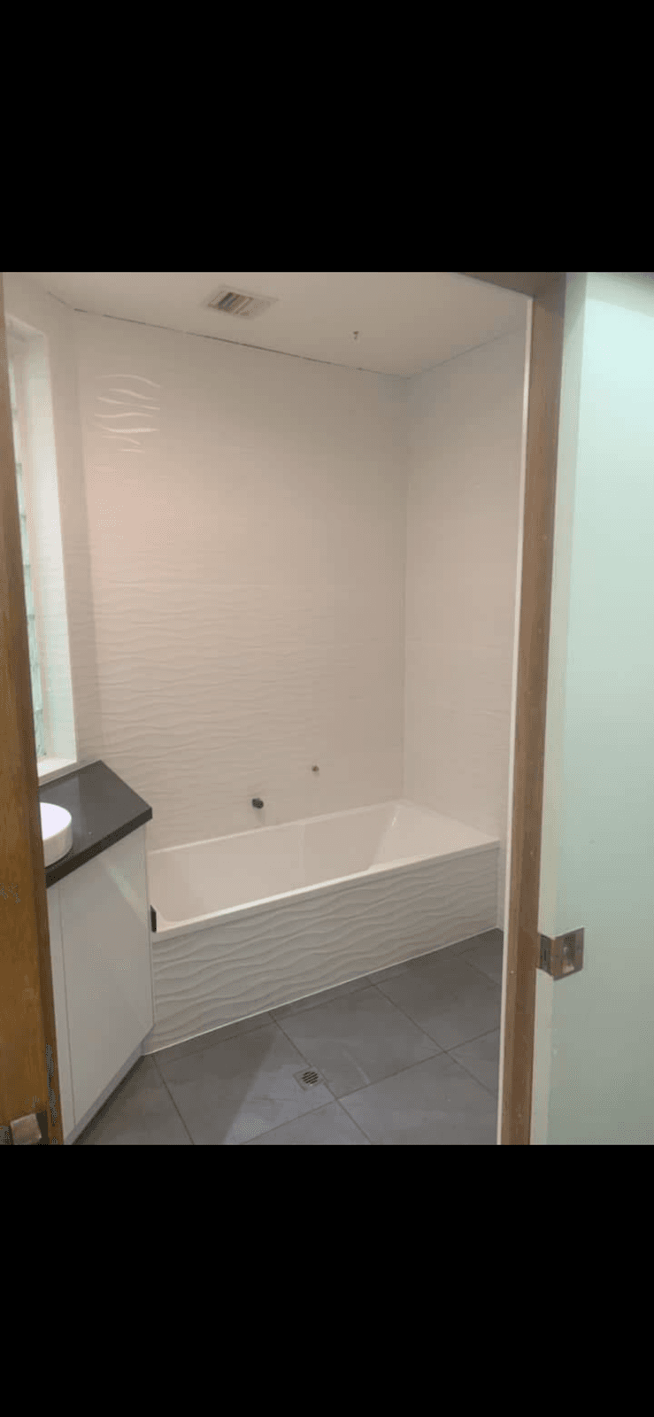 Bathroom with Wave-Texture Wall Tile & Bathtub